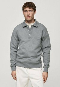 Grå sweatshirt med krage, treknapps stängning och ribbade ärmslut och nederkant. Tillverkad av mjukt fleecematerial med en avslappnad passform.