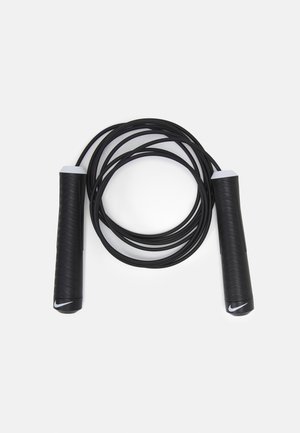 Black jump rope with ribbed black grips and white accents, featuring a flexible cord coiled in a loop, minimalistic design.