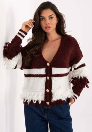 Gestrickte Strickjacke in Burgunderrot und Weiß, mit tiefem V-Ausschnitt, goldenen Knöpfen und strukturierten Fransen an Ärmeln und Saum.