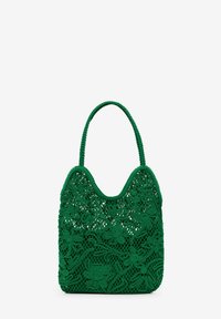 Vihreä virkatasku, jossa on kukkakuviot, teksturoitu pinta ja pyöreä kahva. Suunniteltu avoimilla neuleelementeillä tyylin ja hengittävyyden vuoksi.