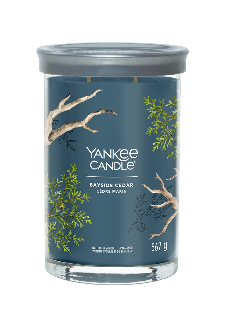 Glasljus med en mörkblå etikett som har grön flora och trädgrenar. Silverfärgad metallock; produktvikt 567 g.