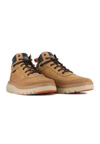 Une paire de baskets montantes beiges avec des lacets noirs et orange, des semelles beiges et des cols de cheville rembourrés noirs, orientée vers la gauche sur fond blanc.