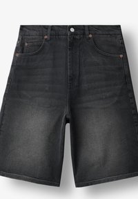 Pantalones cortos de mezclilla negros con bolsillos frontales, presillas para cinturón, botón metálico y textura ligeramente desgastada en los muslos.