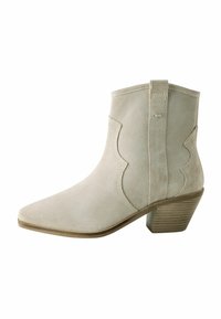 Botín de ante beige con punta afilada, diseño con forma de concha y tacón apilado. Textura suave con detalles de costura en los lados.