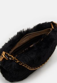 Czarna torebka z futerkiem z imitacji, z paskiem łańcuszkowym w kolorze złotym. Posiada zamknięcie na zamek błyskawiczny oraz podszewkę z kilkoma kieszeniami.