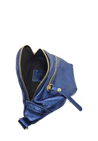 Sac en cuir métallisé bleu avec des zips dorés, design en forme de cœur, doublure textile et une bandoulière amovible pour plus de polyvalence.