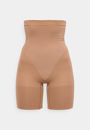 Magas derekú, bézs alakformáló rövidnadrág combközépig érő, varrás nélküli kialakítással és támogató kompressziós anyagból.