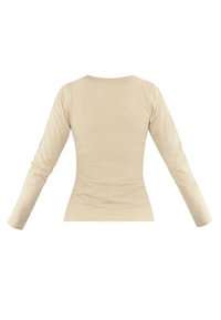 Langärmliges, eng anliegendes Oberteil aus weichem beigen Material. Mit rundem Ausschnitt und glatter Textur, ohne sichtbare Muster oder Akzente.