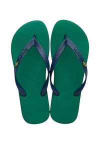 Chanclas de goma verdes con suelas texturizadas, que presentan correas azul marino y un pequeño emblema amarillo y verde en la correa izquierda.