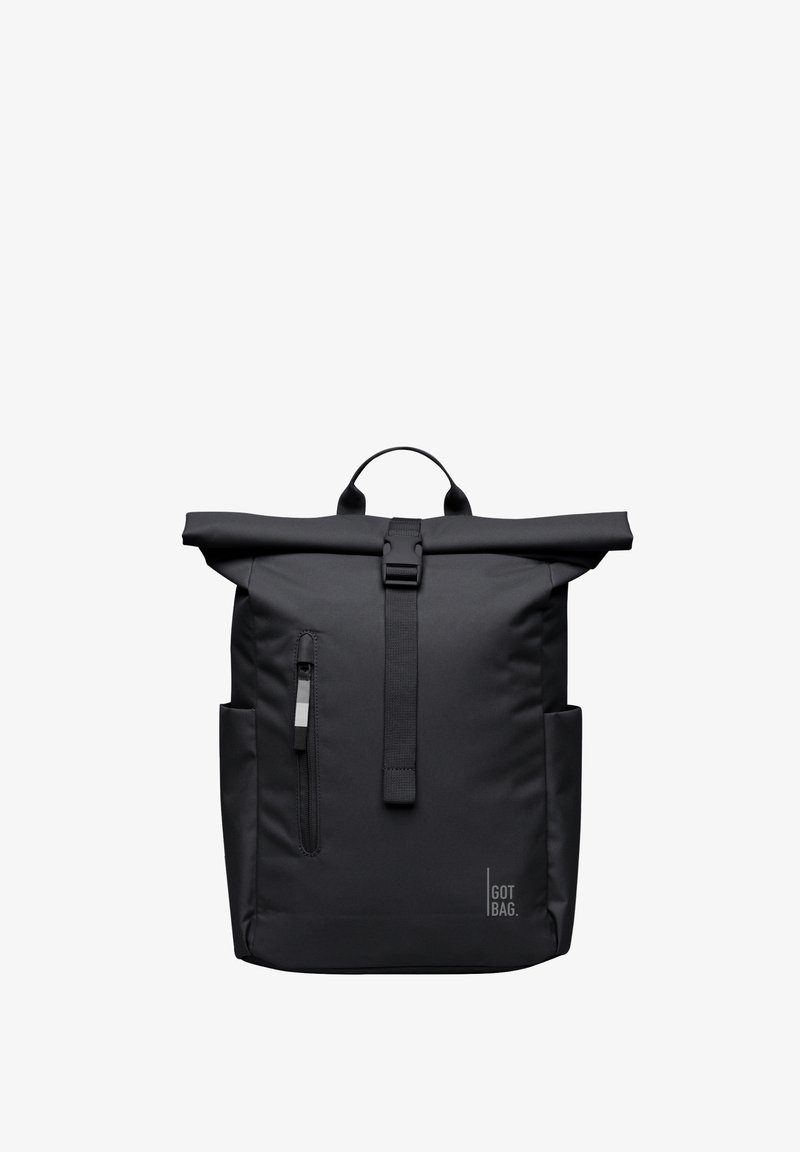 Sac à dos noir à rabat enroulable avec boucle frontale, poche zippée verticale, poches latérales et logo "GOT BAG" en bas à droite.