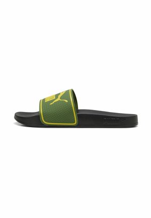 Schwarze Slide-Sandale mit grün strukturiertem Riemen und gelbem Puma-Logo, seitlich mit Puma-Prägung.