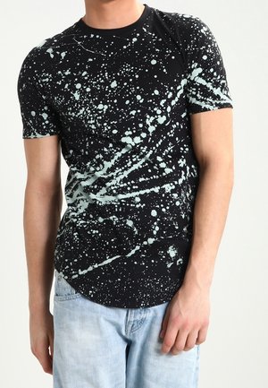 Sort kortærmet t-shirt med et sprøjtet mønster i mintgrøn. Blødt stof, tætsiddende design, rund afslutning og rund halsudskæring.