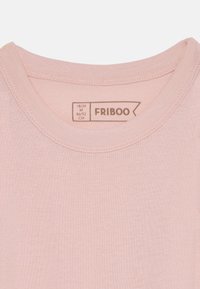 Lys rosa bomull T-skjorte med rund hals, myk tekstur, og etikett med merkevarenavnet "FRIBOO" og størrelseinformasjon.