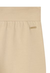 Pantalones de cintura elástica en color beige con una textura suave, que cuentan con un pequeño acento dorado del logo en la cintura y un detalle de recogido sutil.