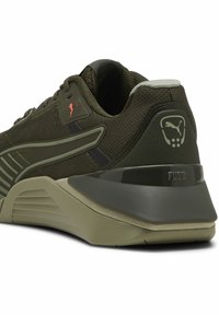 Pantofii sport de culoare verde măsliniu închis au un superior din plasă, un talpă intermediară texturată și o talpă din cauciuc. Au un logo și un accent pe călcâi ridicat.