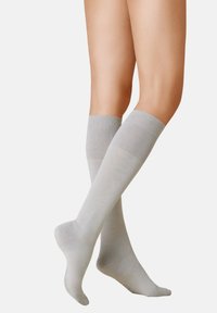 Hellgraue knielange Socken aus einem glatten, weichen Material mit einem gerippten Bund und einem nahtlosen Zehenbereich.