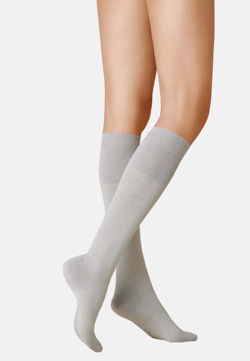 Hellgraue knielange Socken aus einem glatten, weichen Material mit einem gerippten Bund und einem nahtlosen Zehenbereich.