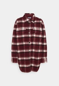 Chemise en flanelle rouge et blanche avec des accents verts, dotée d'un col, de manches longues, de deux poches avant et de boutons. Texture douce.