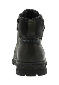 Bottes courtes vert foncé avec un extérieur en cuir texturé, une doublure duveteuse, une fermeture éclair latérale, et une semelle en caoutchouc noir avec une bande de roulement à motif.