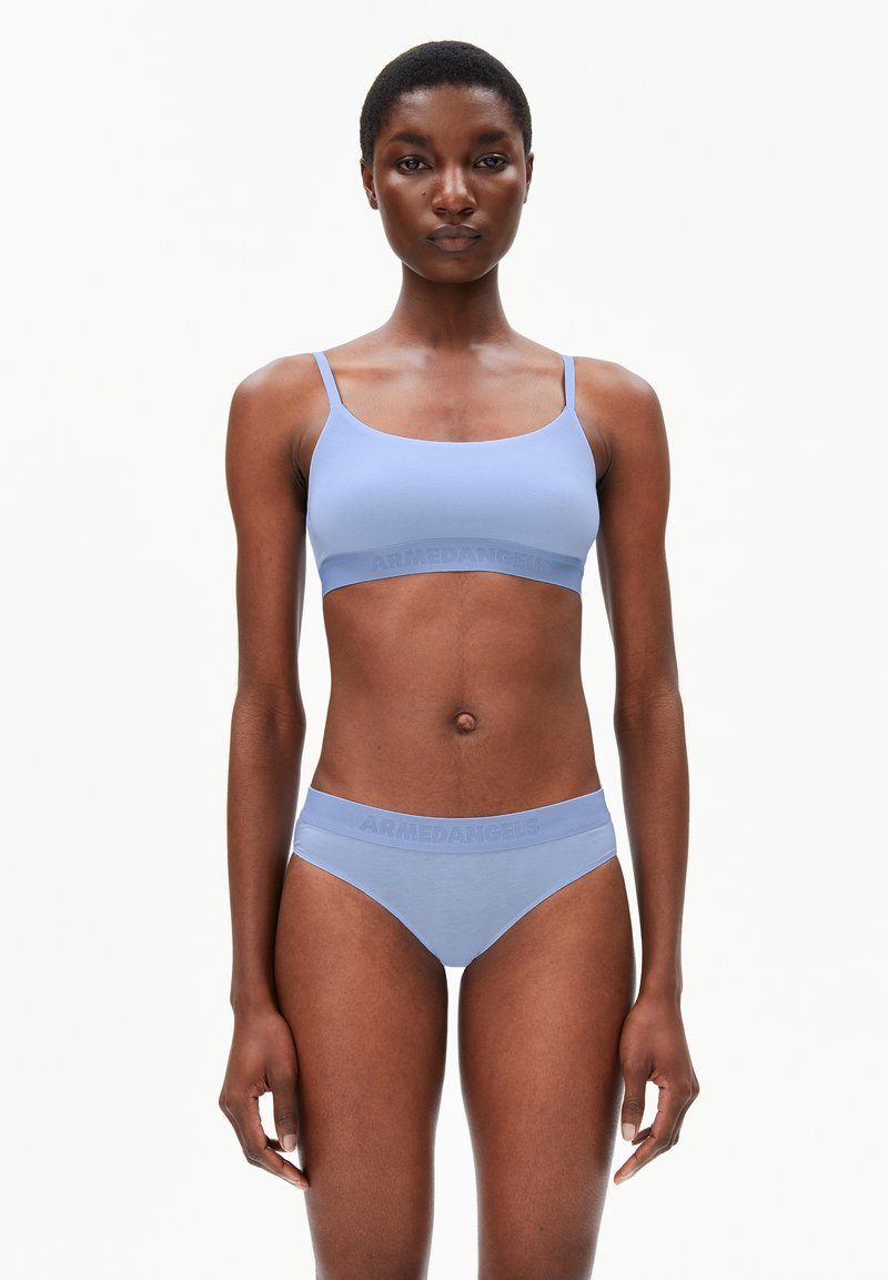 Ensemble de soutien-gorge et culotte bleu clair en tissu doux et extensible. La ceinture présente un logo en relief discret. Design simple, bords sans couture.