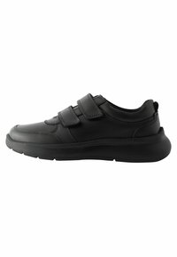 Zapatillas deportivas negras con una parte superior de cuero suave, dos tiras de velcro, puntera redondeada y una suela de goma texturizada para mayor tracción.
