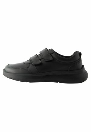 Chaussures de sport noires avec une tige en cuir lisse, deux bandes Velcro, un bout arrondi et une semelle en caoutchouc texturé pour l'adhérence.