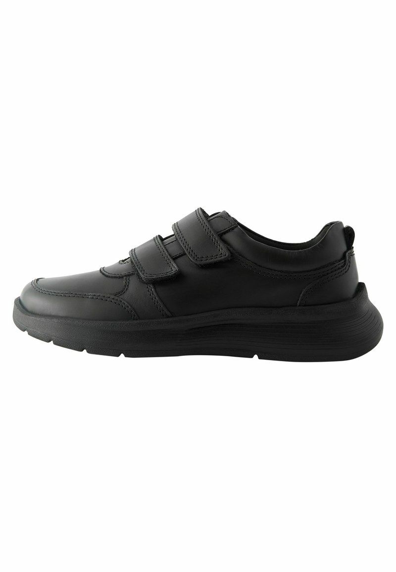 Zapatillas deportivas negras con una parte superior de cuero suave, dos tiras de velcro, puntera redondeada y una suela de goma texturizada para mayor tracción.