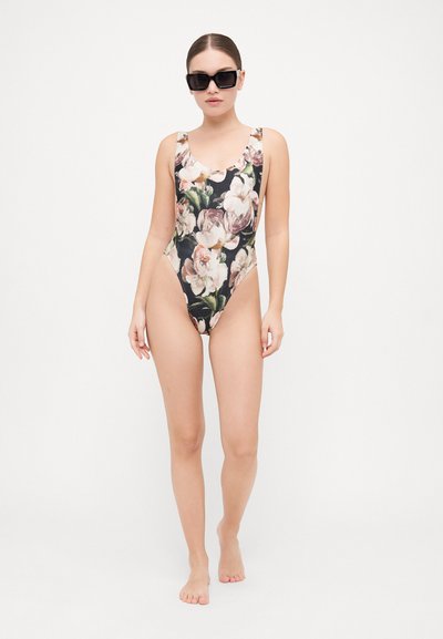 Floral one-piece swimsuit with a black background, featuring large pink and cream flowers. Smooth fabric, low back, and wide straps.