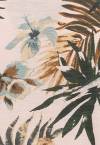 Tissu à motifs avec un fond rose clair, des fleurs tropicales en bleu doux, marron et vert, avec une apparence texturée et tissée.