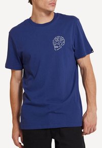 Blue cotton t-shirt featuring a white skull graphic on the chest, short sleeves, and a crew neckline. Smooth texture and casual cut.