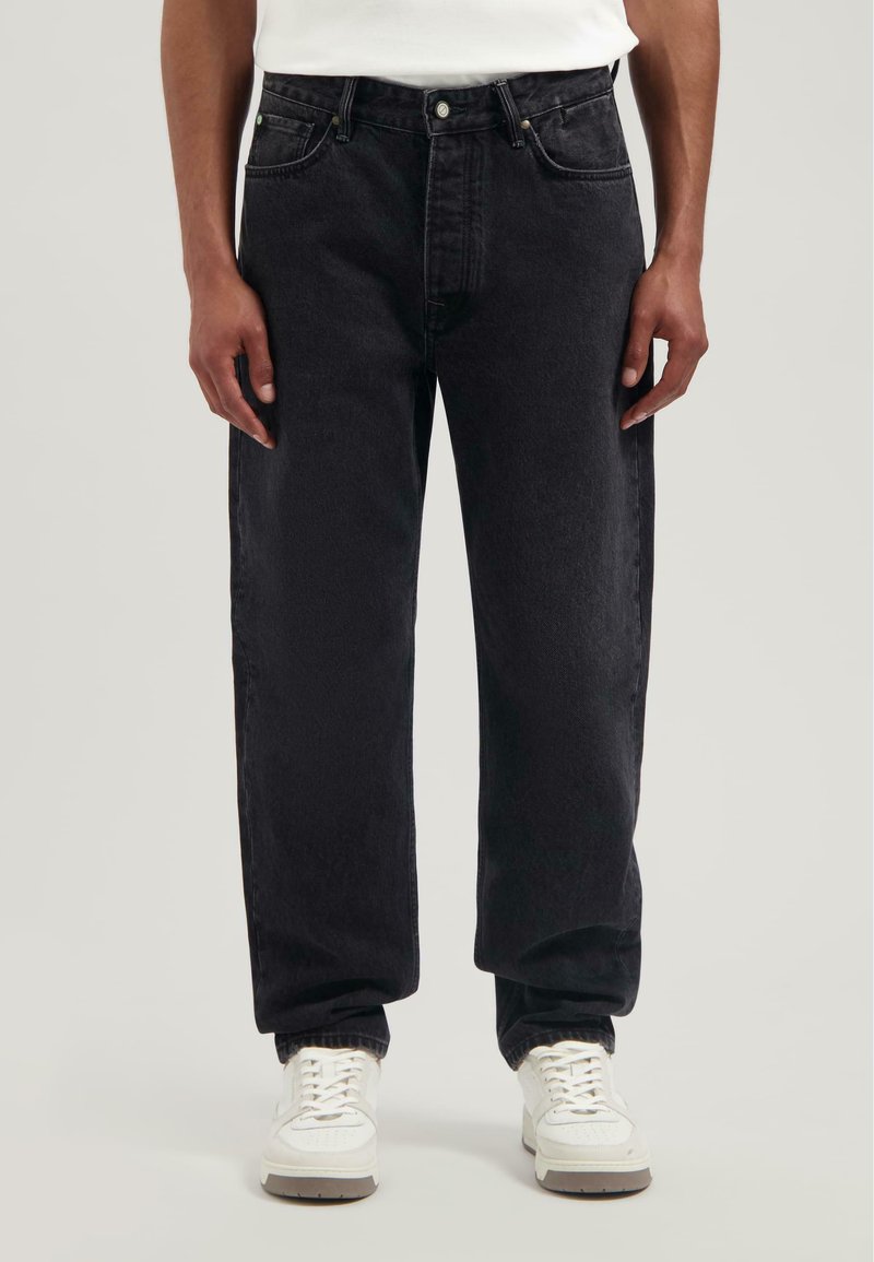 Czarne dżinsy o luźnym kroju, z zapięciem na guzik i zamek błyskawiczny, pięcioma kieszeniami oraz subtelnymi detalami w stichingu.