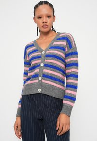 Grå cardigan med vertikale striper i rosa og blå, med V-hals, knappelukking og teksturert stoff.