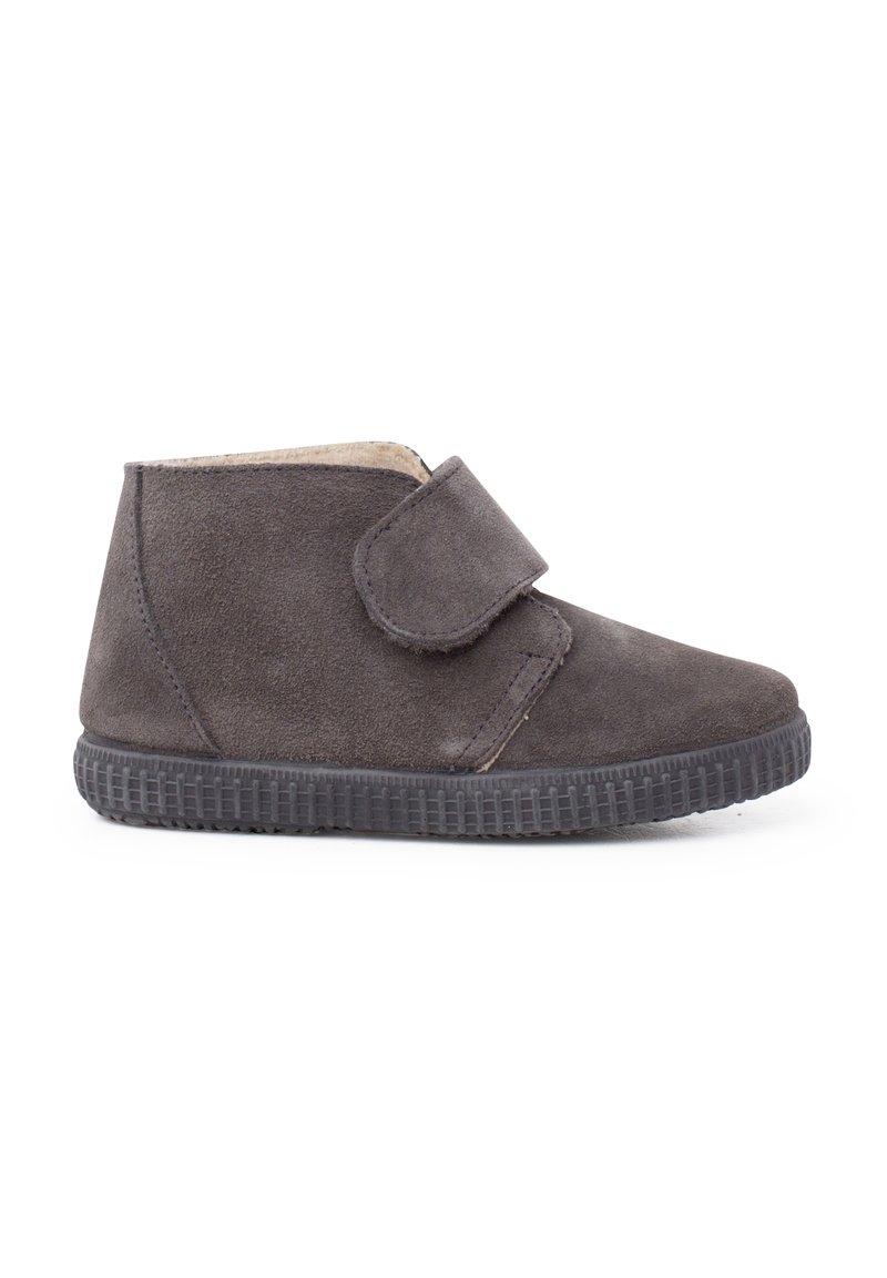 Stivale alla caviglia in suede grigio con una fascia in Velcro, superficie testurizzata e suola in gomma nera. Design semplice, adatto per un abbigliamento casual.