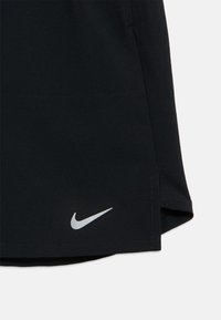 Shorts de sport noirs avec logo Nike argenté. Tissu léger, design épuré et fentes latérales pour une meilleure mobilité.