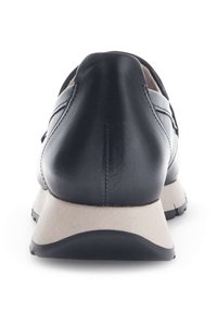 Zwarte leren schoen met een ronde hak, lichtgekleurde zool en subtiele naaddetails. Gladde textuur, modern ontwerp en minimalistische stijl.