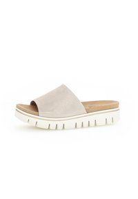 Scarpe aperte in suede beige con un'ampia apertura sulla punta, suola platform spessa di colore bianco e dettagli testurizzati visibili sul bordo della suola.