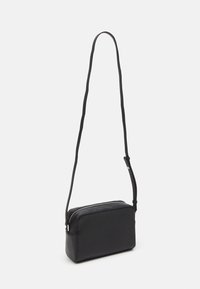 Borsa a tracolla nera in ecopelle, caratterizzata da una forma rettangolare, chiusura con zip e una tracolla regolabile. Texture liscia con un design minimale.