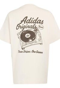 Krémové tričko s velkým černým motivem gramofonu a textem: "Adidas Originals Records" a "Three Stripes. One Groove."