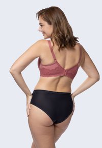 Rose lace-back bra with adjustable straps, paired with high-waisted black briefs. Smooth fabric and a seamless design create a clean silhouette.