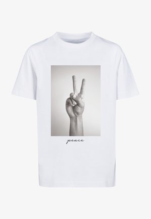 Biała koszulka z czarno-białym zdjęciem ręki pokazującej znak pokoju i słowem „peace” napisanym poniżej.