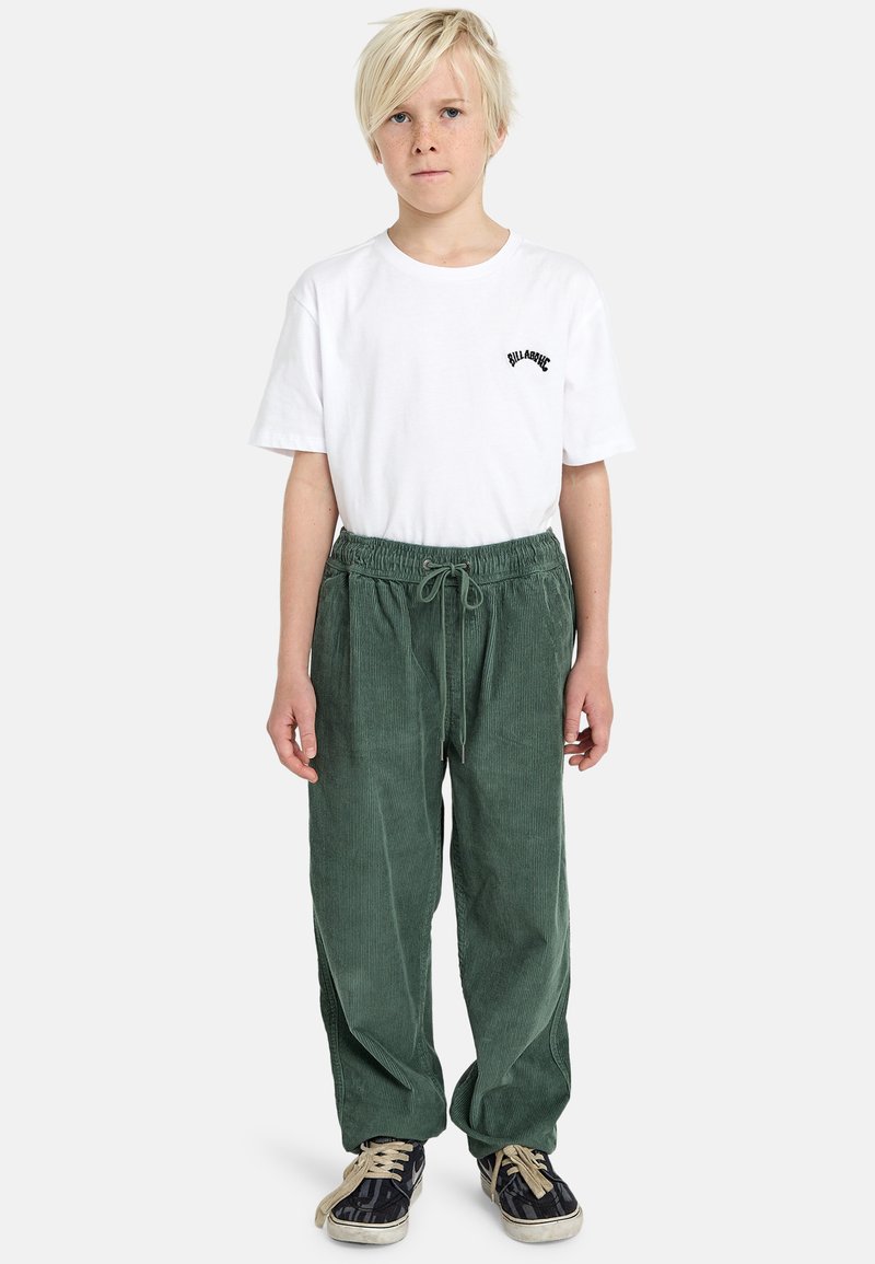 Groene corduroy broek met een elastische tailleband en een trekkoord, gecombineerd met een wit T-shirt met een klein zwart logo.