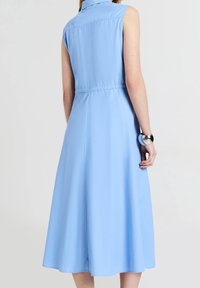 Jasnoniebieska sukienka bez rękawów z kołnierzykiem, wcięciem w talii i zwiewnym spódnicą w kształcie litery A. Gładki materiał z prostym wzornictwem i bez widocznych wzorów.