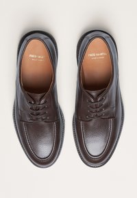 Braune Lederschuhe mit strukturiertem Finish, runder Zehenform und Schnürdesign. Verfügen über ein glattes Innenfutter und subtile Nähdetails.