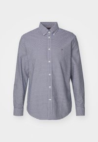 Koszula zapinana na guziki w granatowo-białą kratę w gingham, z kołnierzykiem, długimi rękawami i małym logo na kieszeni piersiowej.