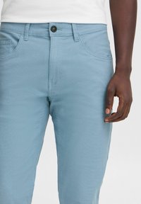 Lichtblauwe broeken van textiel met een gestructureerde stof, met een ritssluiting aan de voorkant, zijzakken en een slim-fit ontwerp.