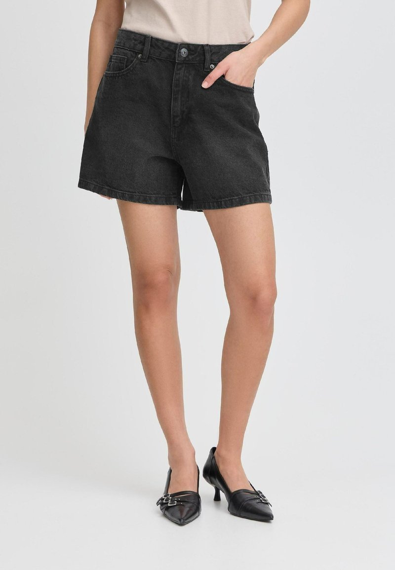 Shorts en denim noir à taille haute, avec poches avant et coupe décontractée. Le tissu a une texture lisse et un léger brillant.
