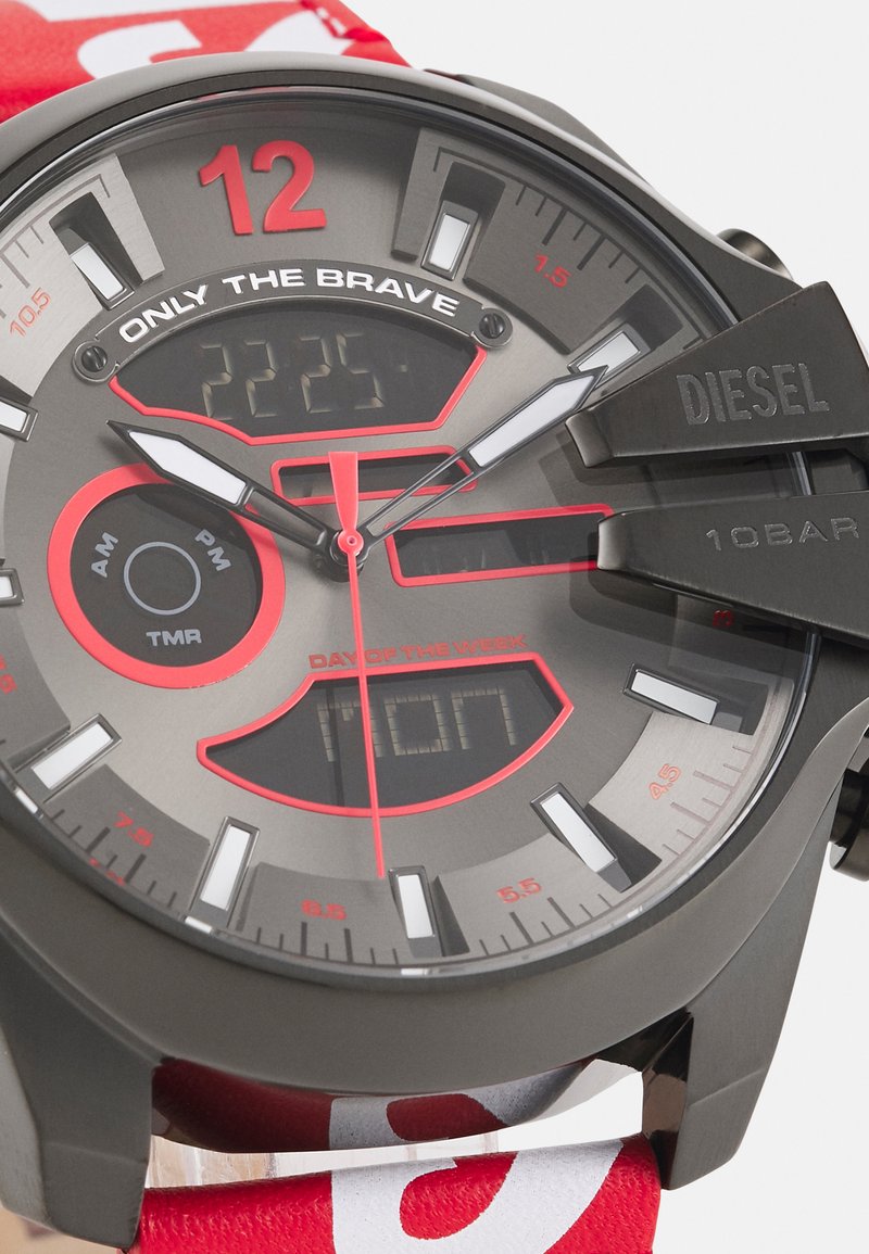 Fekete és szürke digitális-analóg óra piros kiegészítőkkel, kerek tokkal, markáns számokkal és logóval, valamint mintázattal ellátott szövet szíjjal.