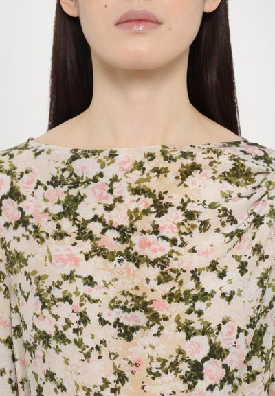 Floral-patterned, light fabric top with a boat neckline, featuring pink roses and green foliage against a beige background. Smooth texture.