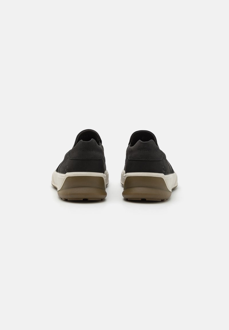 Czarne sneakersy z gładką cholewką, białą podeszwą środkową i brązową gumową podeszwą, o niskim profilu i bez widocznych sznurówek.
