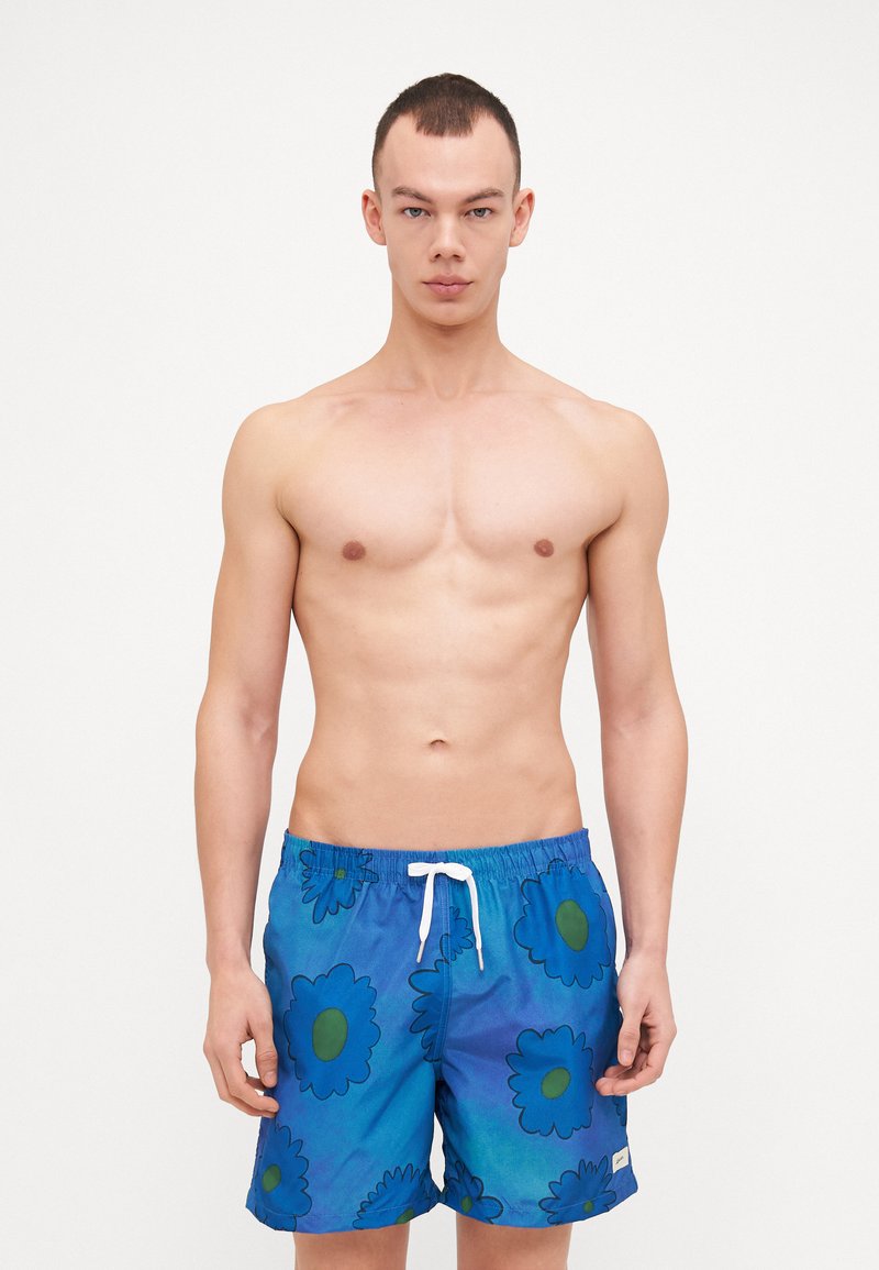 Pantaloni da bagno blu con motivo floreale caratterizzato da fiori blu scuro e centri verdi. Realizzati in tessuto leggero con vita elastica.